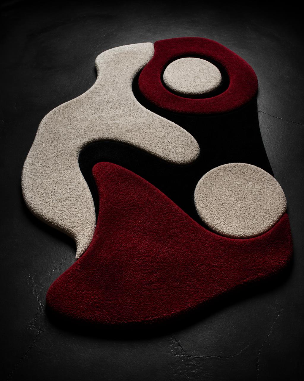 Bold hand-woven geometric rug leaning against a concrete wall at dusk